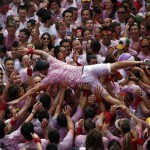 A reveller gets carried in the air by the crowd during the start of the San Fermin Festival in Pamplona